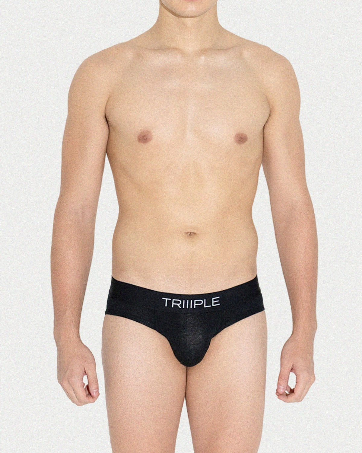 Person wearing a black men's underwear with 'TRIIPLE' branding on a white background